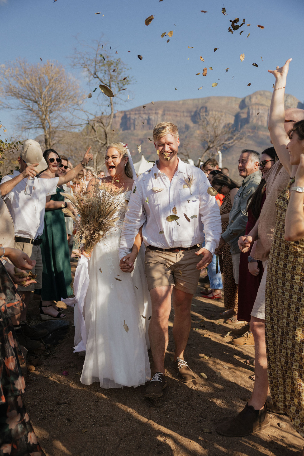 Newlyweds walking through falling leaves and confetti