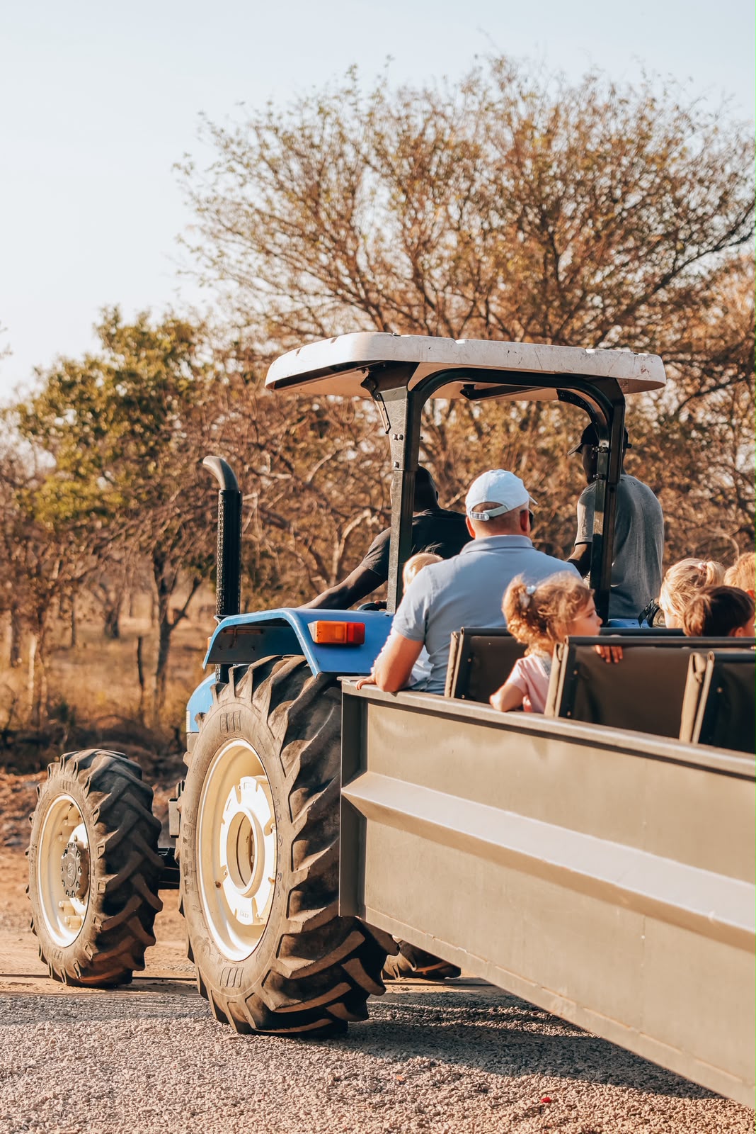 Farm tractor pulling a wagon of guests along a gravel road on the farm