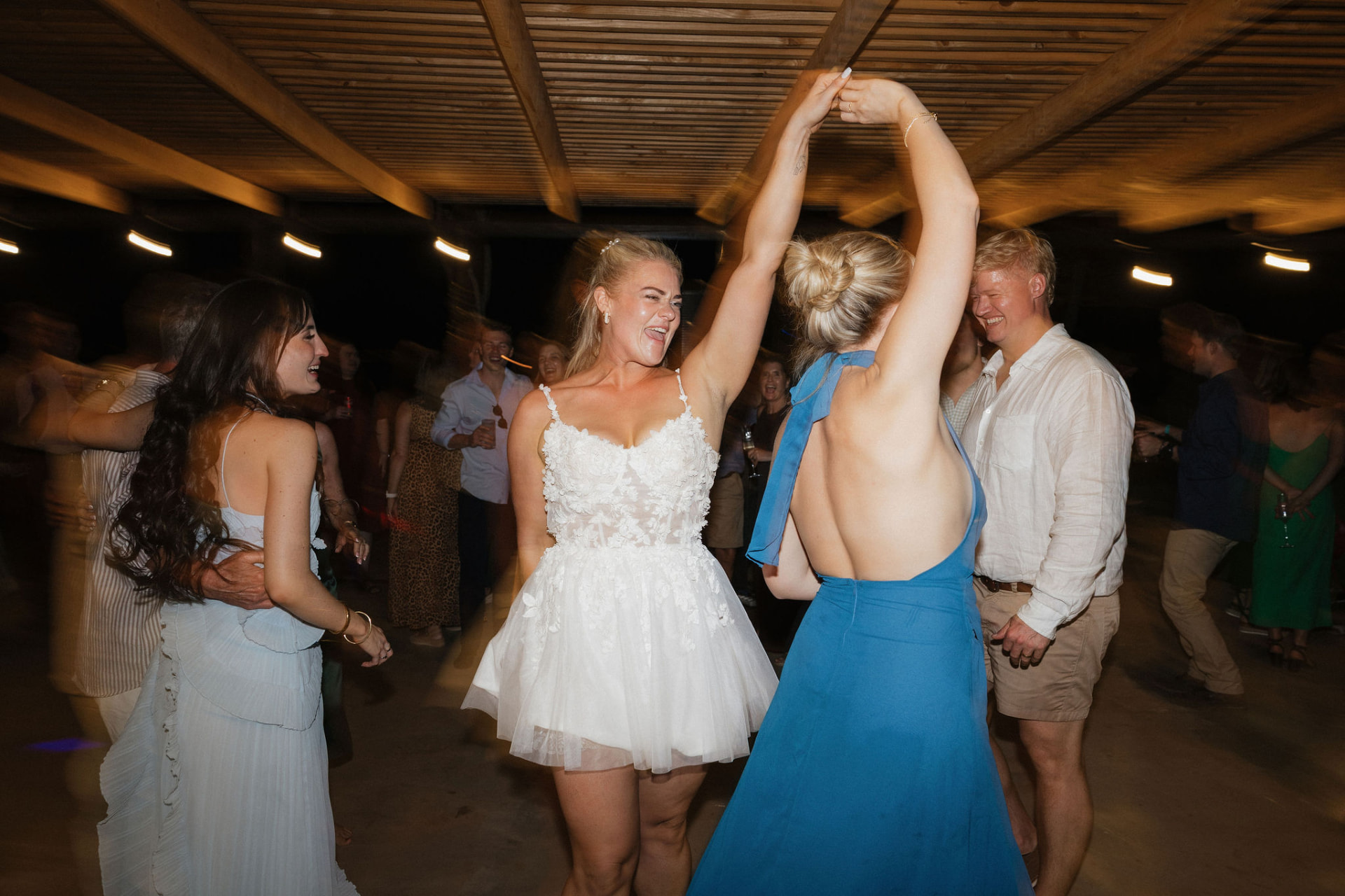 The bride dancing with guests on the dance floor after dark